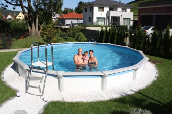 eine jung Familie in einem Cranpool Rundbecken Das Becken ist gut gepflegt das becken steht in einem Garten und hat eine Umrandung aus Kieselsteinen