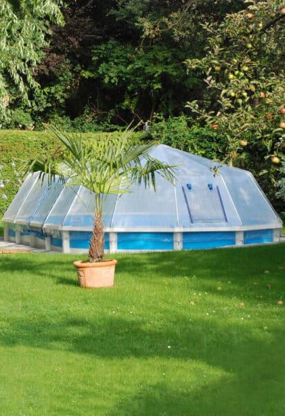 Stahlwand-Swimmingpool Royal von Cranpool, ein ovales Becken mit Sonnendom. Es wurde teilversenkt ins Erdreich.