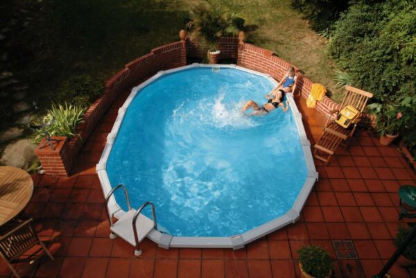 Mutter und Tochter beim entspannen am ovalbecken. Das ovale Pool von Cranpoolist in die erde eingegraben und von einer Fließen Terasse umgeben