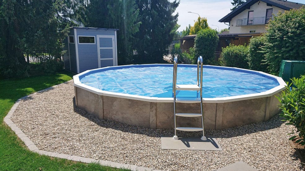 Verkleidung Delux bei einem rundem Pool von Cranpool. Das Schwimmbecken steht in einem Garten