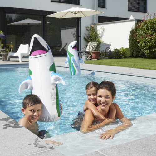 eine Mutter mit zwei kleinen Kindern in einem Schwimmbecken mit Cranpool Flippern, sie sind in einem rechteck Becken in ihrem Garten