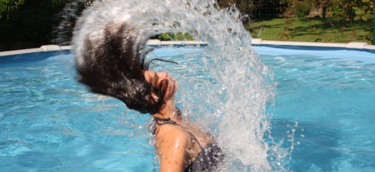 Frau im Cranpool Royal Schwimmbecken, während sie mit nassen Haaren aus dem Wasser auftaucht