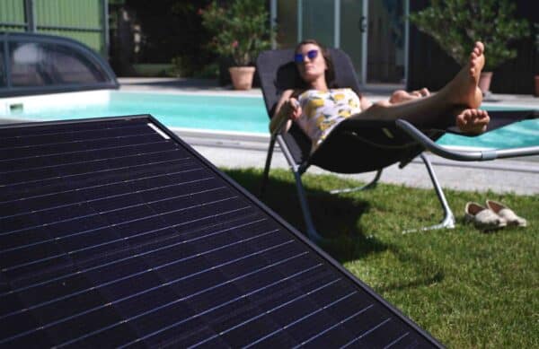 CranSolar, Photovolatik für Pool, Cranpool, grüne Energie, umweltfreundliches Pool, Frau in Liege vor Einbauschwimmbecken, grüner Strom fürs Badevergnügen