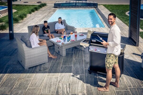 Familie am Pool, Urlaub im Garten, Vater grillt, Cranpool im Hintergrund, Pool & Grillen