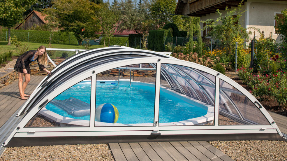 ovales Schwimmbad bodeneben eingebaut mit Cabriodom Poolüberdachung