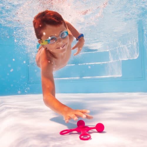 Kind in Pool, Kinderspiele für die Poolparty, tauchender Junge in Schwimmbecken