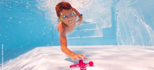 Kind in Pool, Kinderspiele für die Poolparty, tauchender Junge in Schwimmbecken