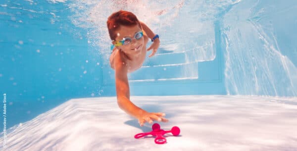 Kind in Pool, Kinderspiele für die Poolparty, tauchender Junge in Schwimmbecken