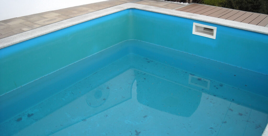 Bildausschnitt eines Pools mit wenig Wasser und Folienverfärbung 