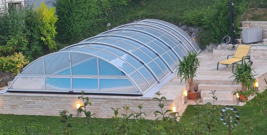 Poolüberdachung Cabriodom geschlossen mit Naturstein Pflasterung 