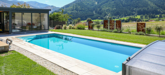 Rechteckiges Cranthermo Pool mit geöffneter Cabriodom Überdachung, Pflasterung um das Becken