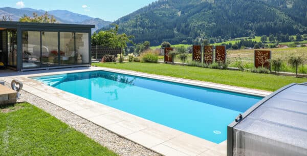 Rechteckiges Cranthermo Pool mit geöffneter Cabriodom Überdachung, Pflasterung um das Becken