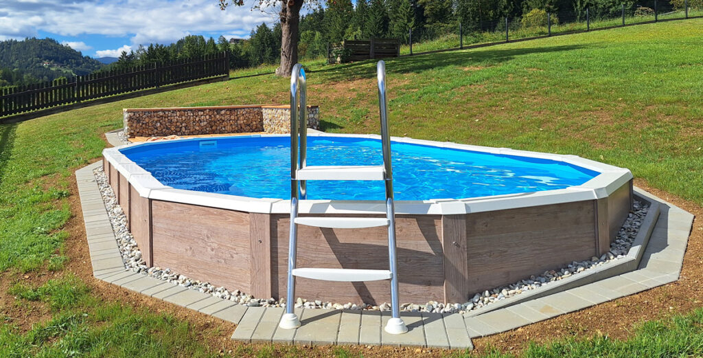 Ovales Pool mit Holzverkleidung in Hanglage und Leiter 
