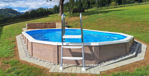 Ovales Pool mit Holzverkleidung in Hanglage und Leiter