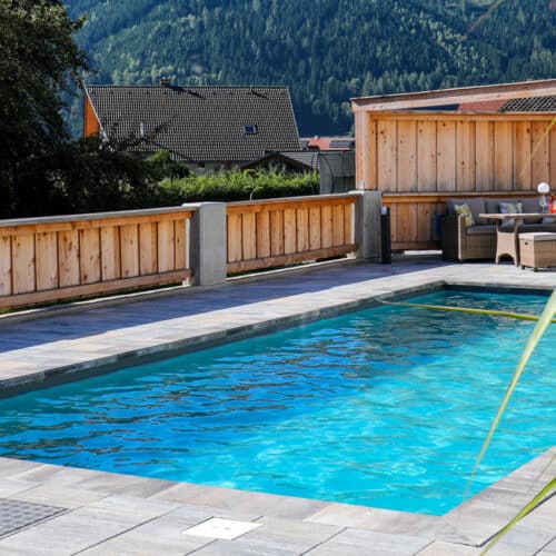 Rechteckiges Pool versenkt mit Umrandung und Holzzaun