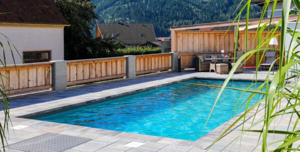 Rechteckiges Pool versenkt mit Umrandung und Holzzaun