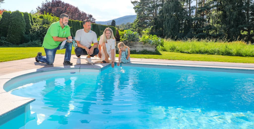 Cranpool Berater am Poolrand mit Familie