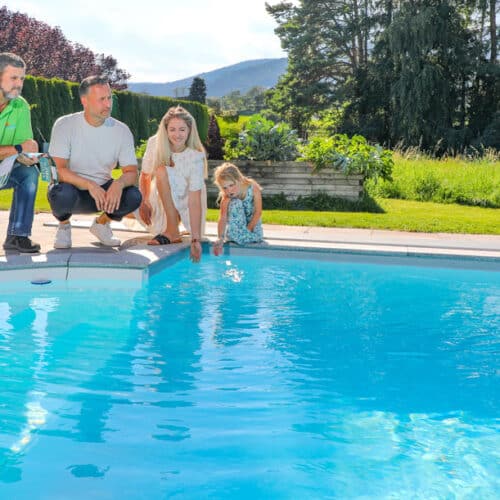 Cranpool Berater am Poolrand mit Familie