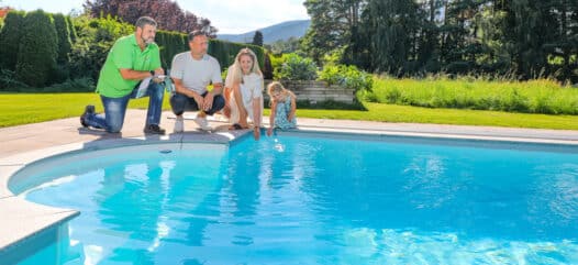 Cranpool Berater am Poolrand mit Familie