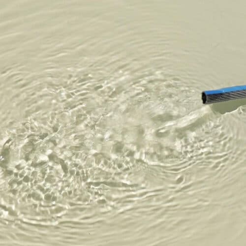 Gartenschlauch mit fließendem Wasser im Pool