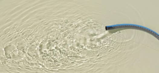 Gartenschlauch mit fließendem Wasser im Pool