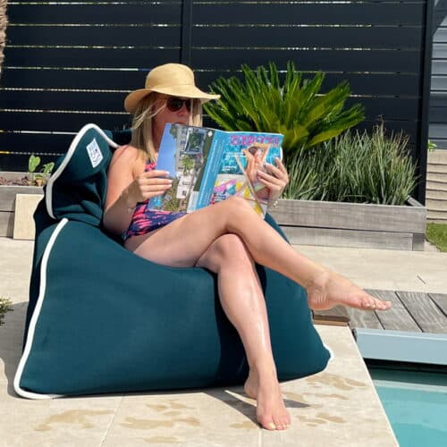 Frau sitzend auf water pouf am pool