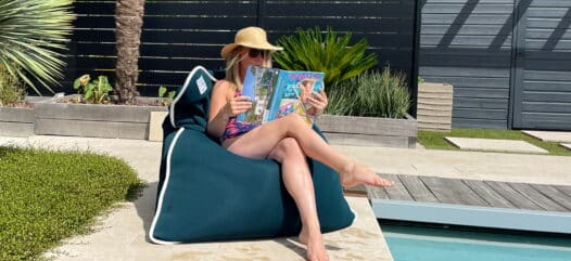 Frau sitzend auf water pouf am pool