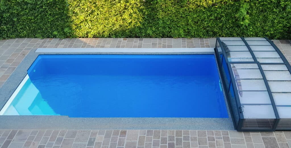 Rechteckiges Ozean Pool mit Poolüberdachung und Ecktreppe 