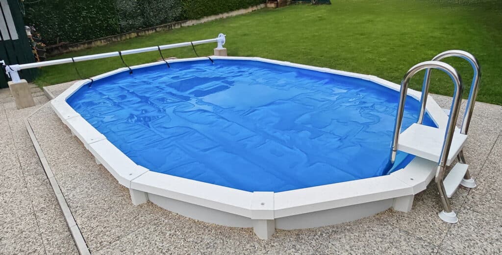 Ovaler Sun Royal Pool, teilversenkt mit Poolleiter und Plattenumrandung im privaten Garten.