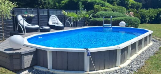 Ovaler Sun Royal Pool, teilversenkt eingebaut mit hochwertiger Verkleidung im privaten Garten.