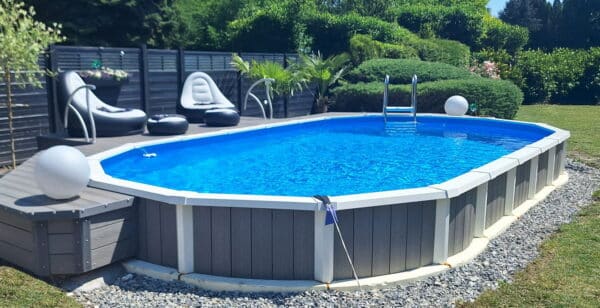 Ovaler Sun Royal Pool, teilversenkt eingebaut mit hochwertiger Verkleidung im privaten Garten.