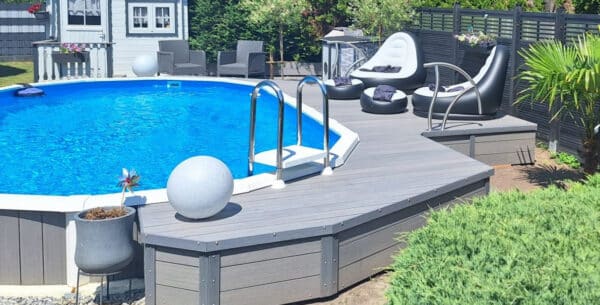 Ovaler Sun Royal Pool mit teilversenkter Ausführung, hochwertiger Verkleidung und Sonnendeck im privaten Garten.