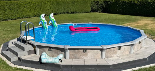 Rundes Pool Modell Rimini teilversenkt mit Poolverkleidung und Leiter. Umrandung mit Pflastersteinen