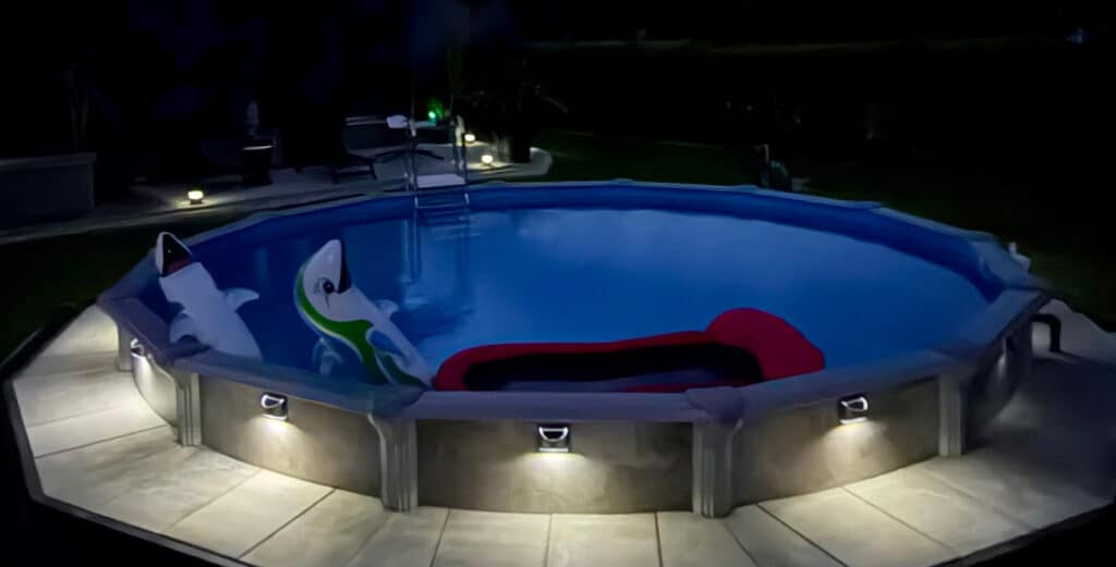 Rundes Pool Modell Rimini beleuchtet, teilversenkt mit Poolverkleidung und Pflasterung