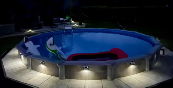 Rundes Pool Modell Rimini beleuchtet, teilversenkt mit Poolverkleidung und Pflasterung